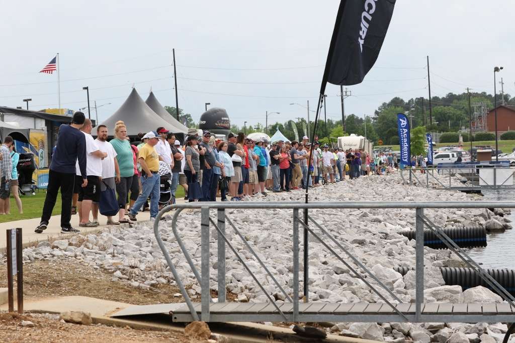 Another line of fans waits above the dock for the first flight of anglers.