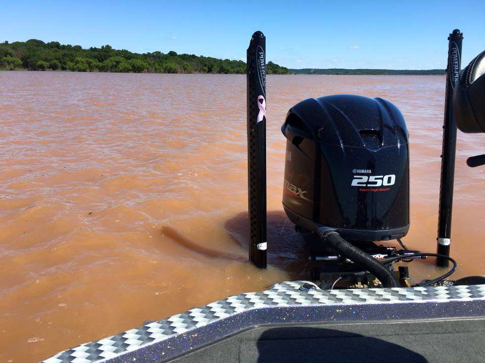 James Niggemeyer shows that recent rains have muddied the water, making it look like he was sitting in red mud. It is the Red River.