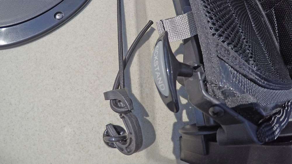 The kickstand cord releases or stows a pair of kickstands in the back of the seat that are meant to raise the back of the chair up. 