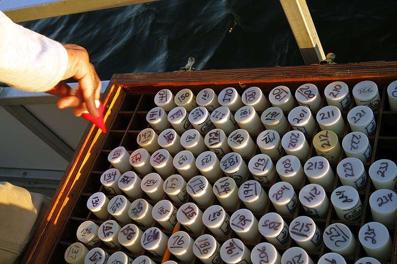 A hand reaches into the box of floating boat fobs. Each has a number corresponding with the boat number that will be used at the check-in site. 