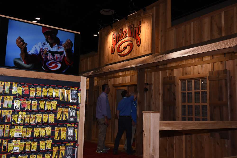 The wood motif continues inside the booth, along with video screens and walls of displayed product.