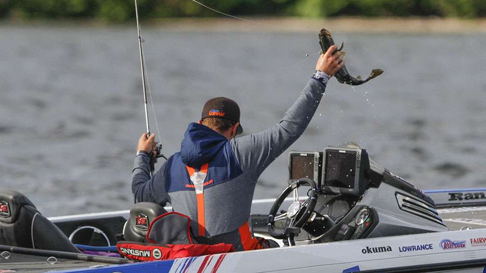 Wheeler grabs his best fish of the morning and hoists it from the water and into the boat.