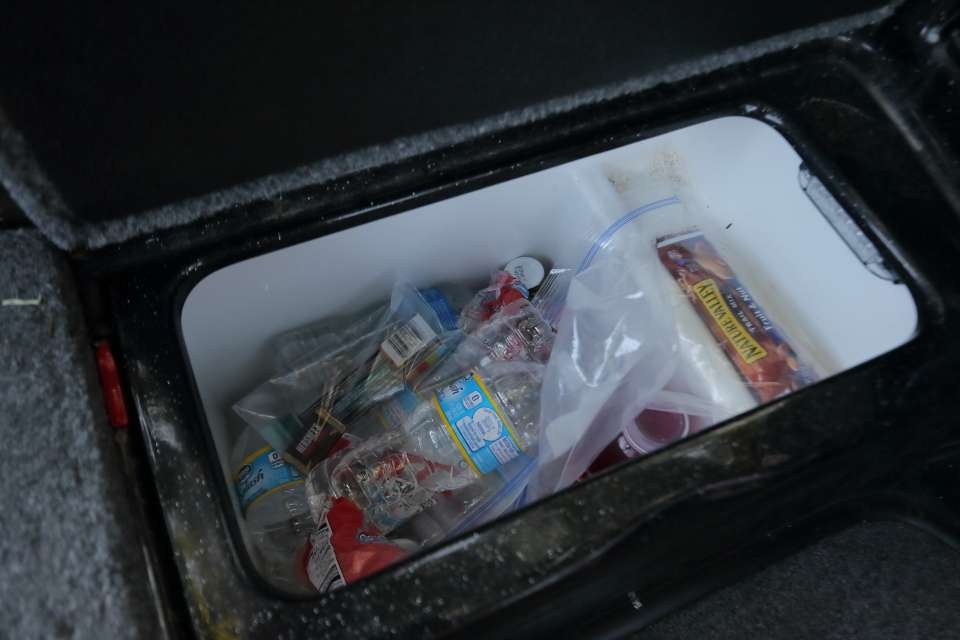 The cooler box with his drinks and snacks.