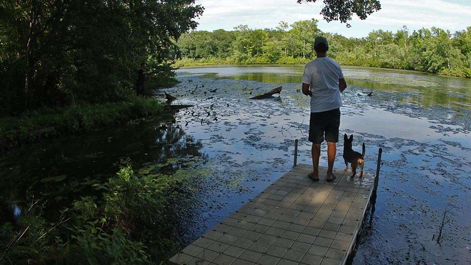Carl Jocumsen, with his part Australian kelpie dog, fishes from the dock right across from Brandon Palaniuk, whoâs hidden in the shadows on this Garden State fishery that Ike calls the No. 2 in the state.
