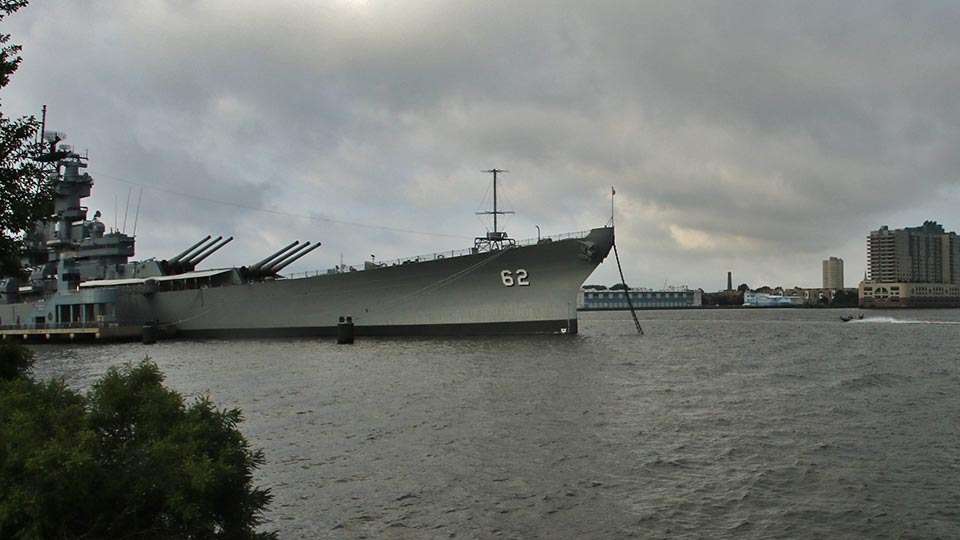 A competitor passes the nearby Battleship New Jersey, which offers tours.