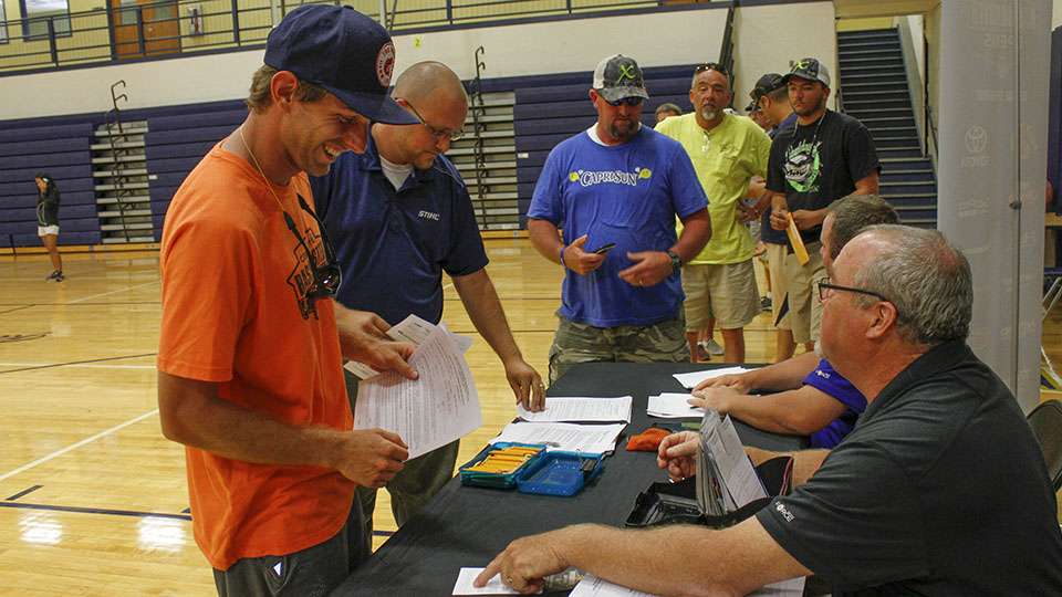 A group of anglers get their information confirmed and their licenses checked.