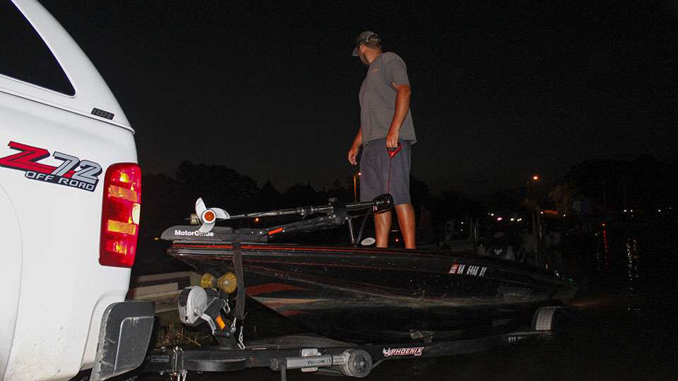 A co-angler backs in the truck as a pro waits to hit the water.