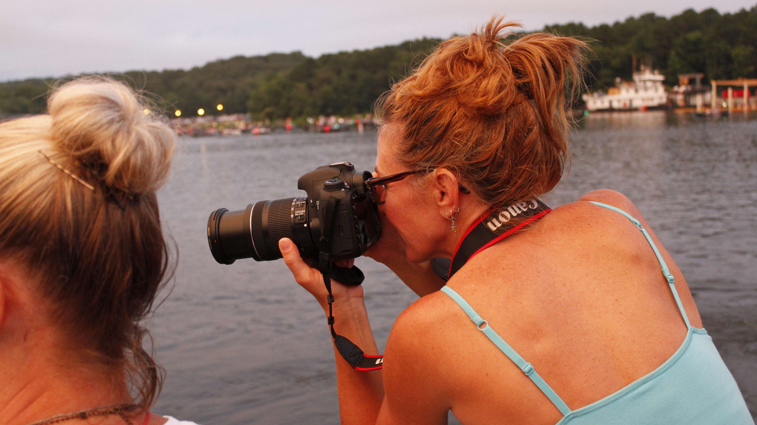 A female fan leans in for a shot of an angler.