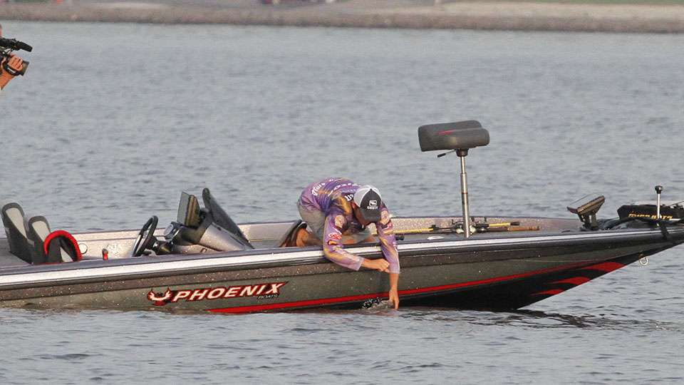 He reaches over the side as he looks to grab a pretty big Kentucky Lake bass. 