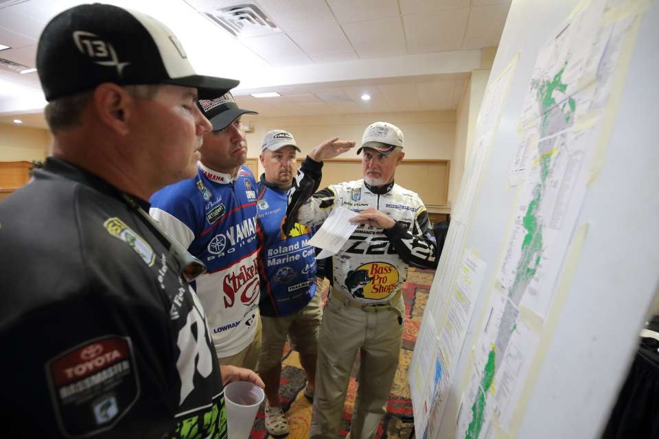 Rick Clunn shows how shallow an area as the anglers share information.
