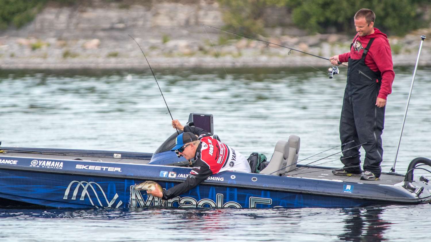 Jones grabs the fish around the belly and lifts it over the side of the boat. 