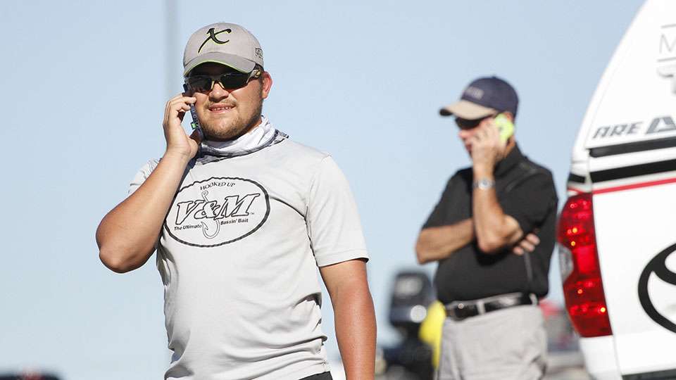Co-angler Justin Cooper talks on the phone after crossing the stage on Day 1.