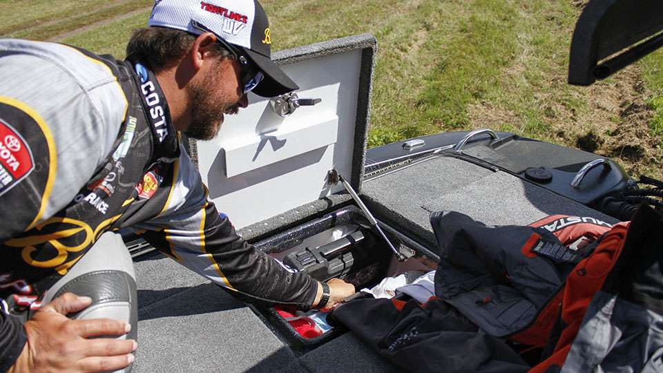 He hops to the back box behind the driver seat to show off his safety parts like his lifejacket and throw cushions. He also had his rain gear stored there, which is one of the biggest necessities for as much as the Elite anglers fish.
