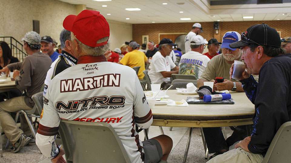 Fishing legend Tommy Martin takes a seat and grabs some food.