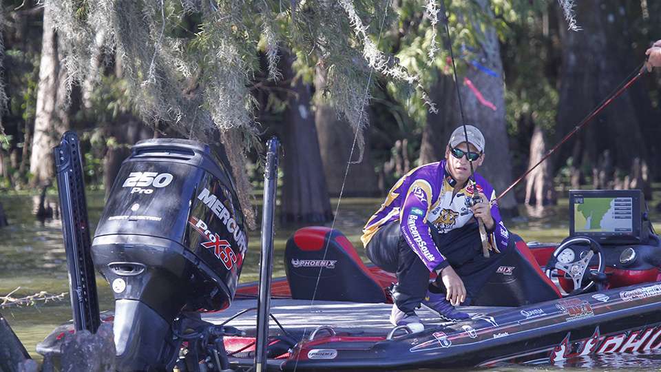 Co-angler Dakota Sparks tries to avoid the tree limbs as he flips to the base of a cypress tree.