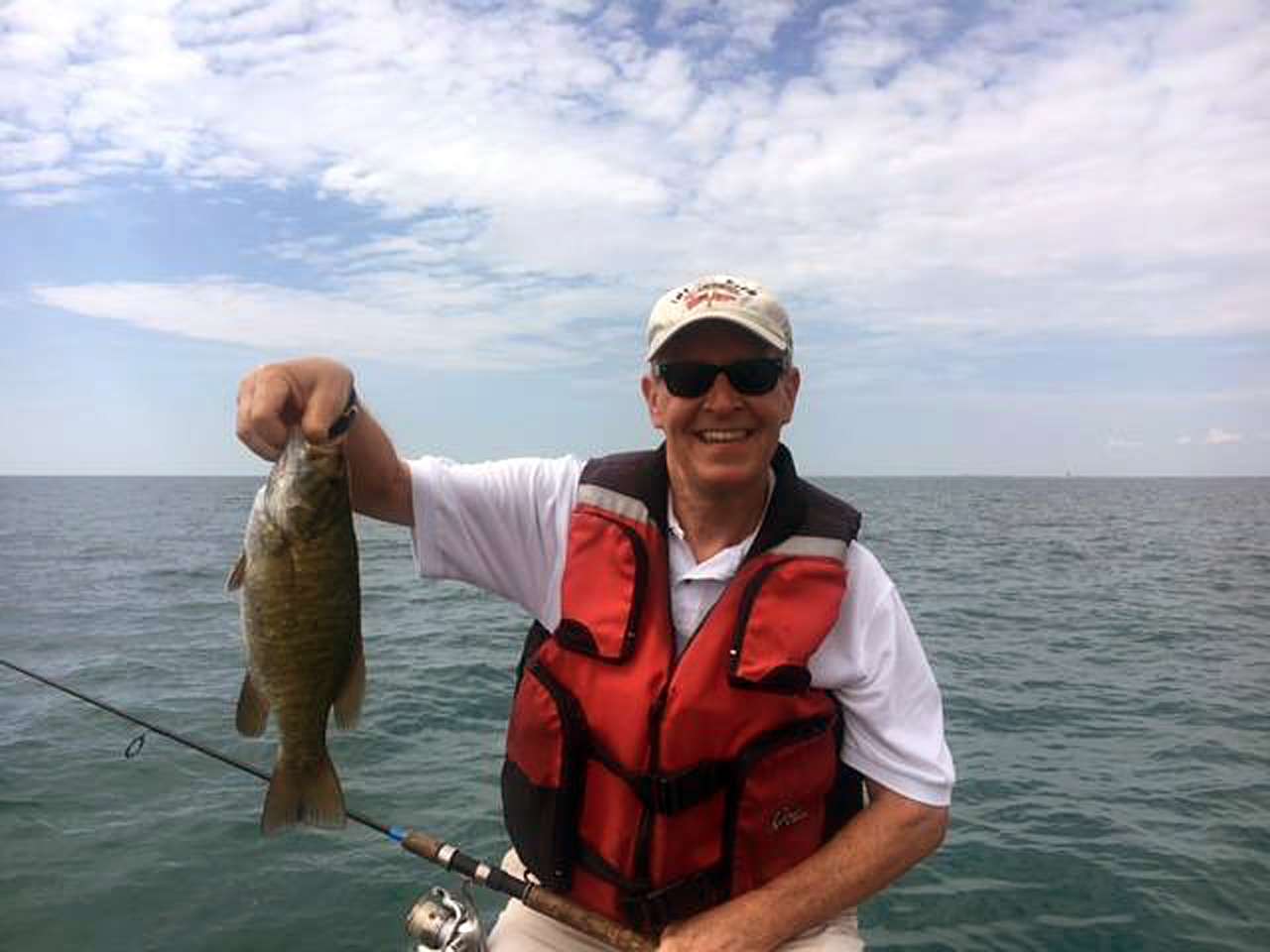 State Rep. Tim Kelly shows off a Lake St. Clair smallmouth bass caught while fishing with boater Dave Reault.