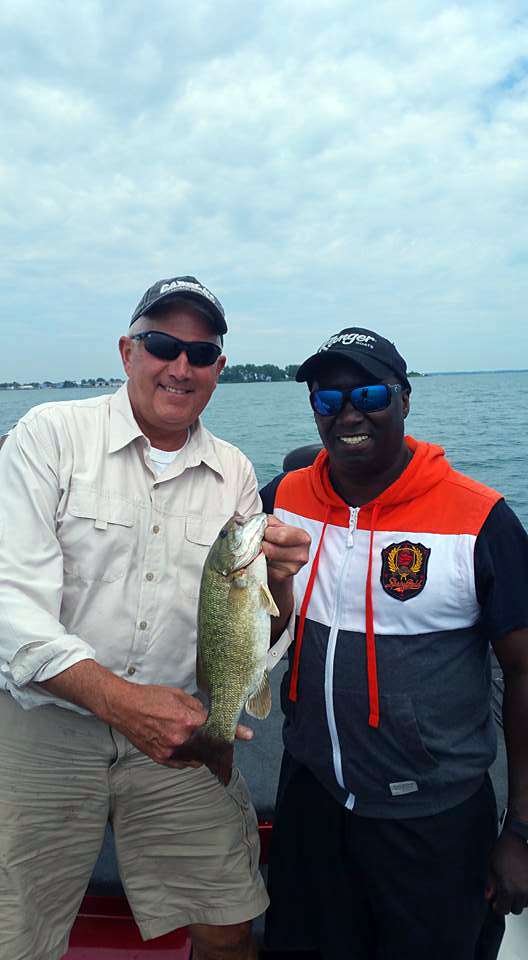 Senator Ken Horn shows off a nice smallmouth bass caught while fishing with boater volunteer Tommy Robinson.