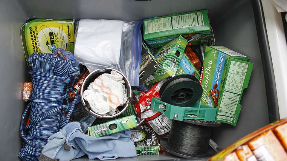 One of his boxes is littered with snacks, rope, a spare prop and even spools of braided line.