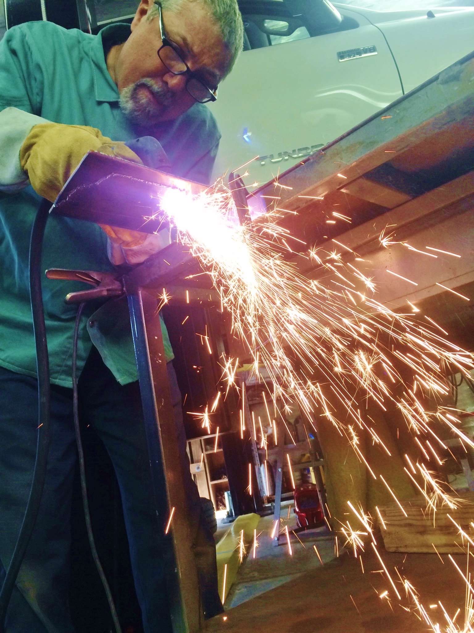 Here a tech uses a torch to fabricate a custom bracket for Adrian Avenaâs rig. 