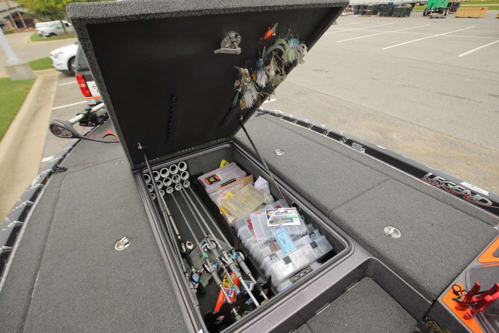 The boat's large center bin is split between more rods and many boxes of tackle. 