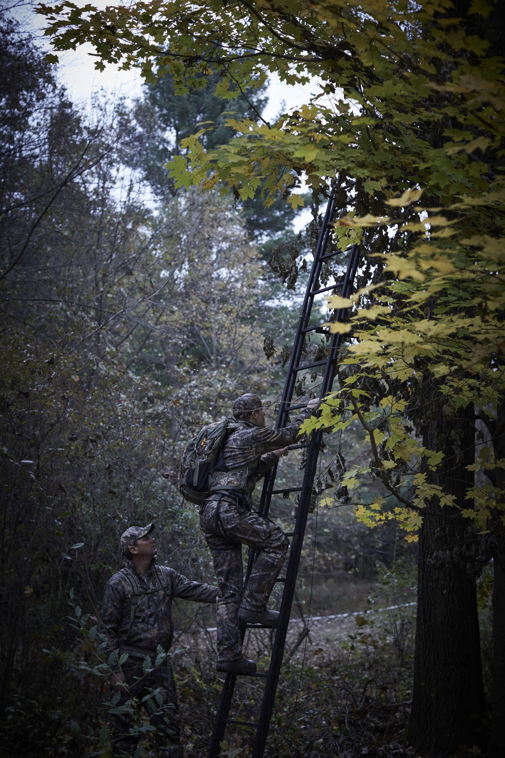 Nicholas heads up his ladder stand with his hunting backpack.