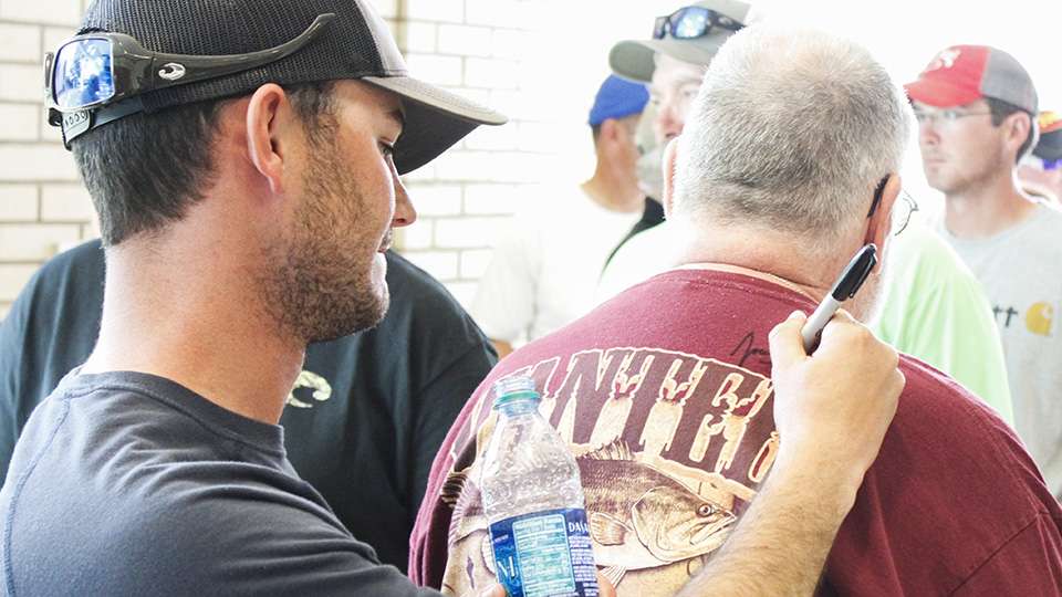 A co-angler gets Jordan Lee's autograph while they wait in line.