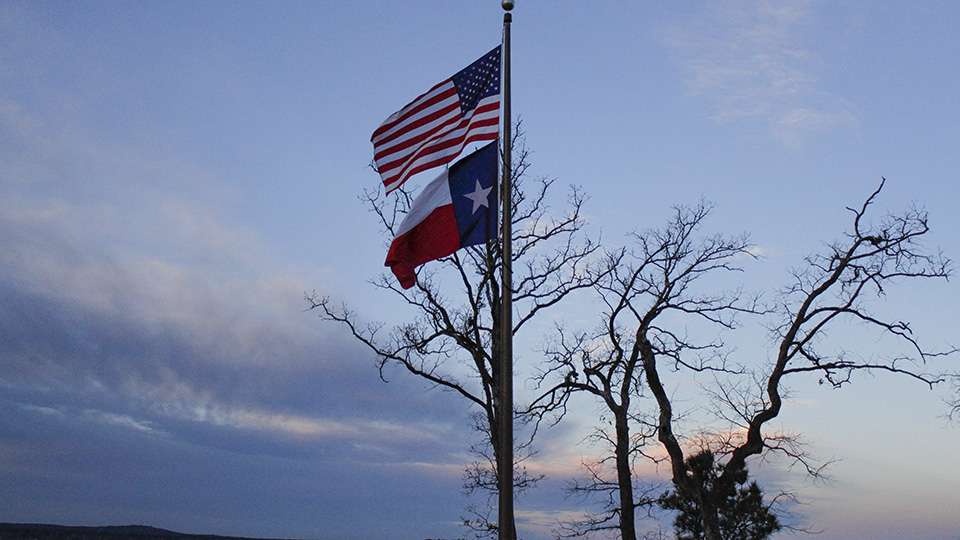 The American Flag and Texas State flag blow in the wind. The morning weather conditions were in the low 40âs with a brisk wind.