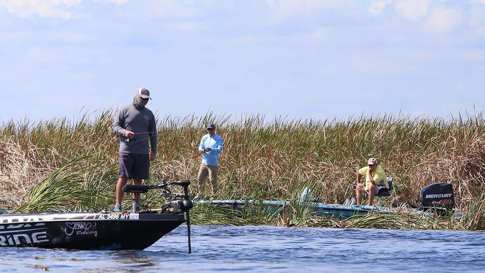 With Steve Kennedy behind him, Jesse Wiggins is using a spinning rod and reel on Okeechobee. But guess what?