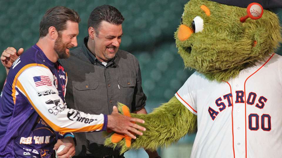 Minnesota Vikings defensive end Brian Robison reaches to shake hands with Orbit, the Houston Astros mascot, as Bassmaster TV host Mark Zona laughs about their first debacle. Robison put one in the dirt, which Zona, a former catcher, blocked and pounced on.