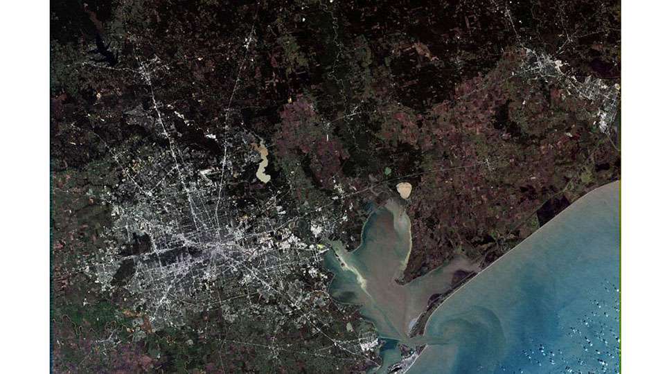 Hereâs a satellite shot of Houston, the fourth largest city in the United States. Thatâs Galveston Bay feeding into the Gulf of Mexico. In the top left corner is Lake Conroe. 