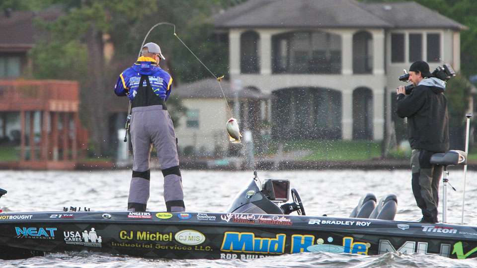 Roy swings his first fish into the boat as the Bassmaster Live camera rolls on the action.