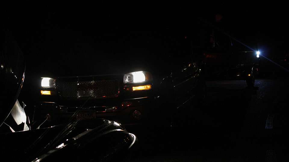 The glow of headlights from competitors pull into the marina.
