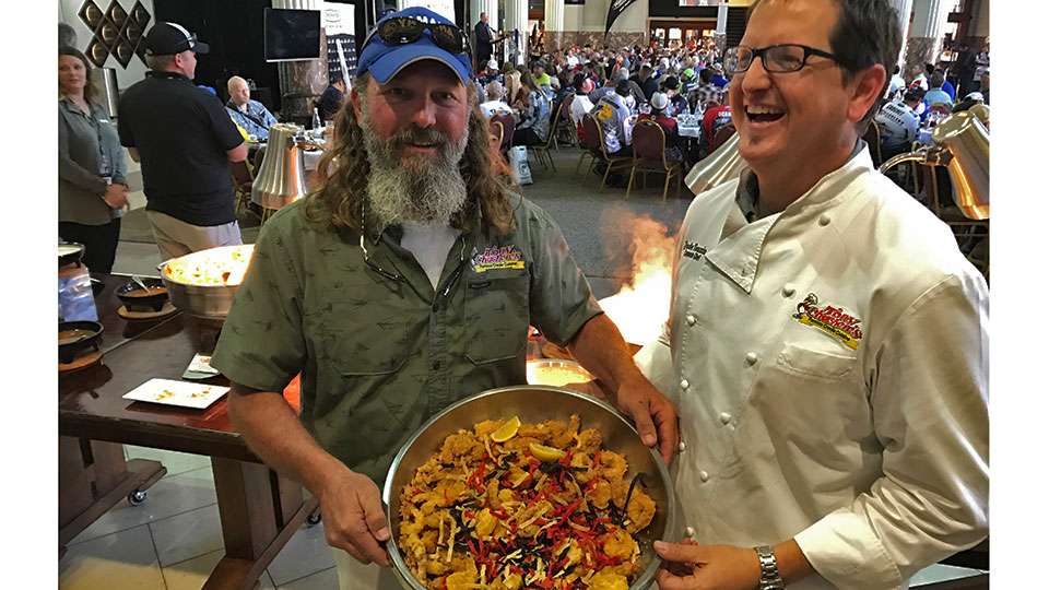 Tony Cachere (left) provides lunch for Media Day, when credentialed media visited with anglers on the eve of competition. Helping Tony, who competes in Opens, hold a spicy shrimp dish is his corporate chef, Jude Tauzin.