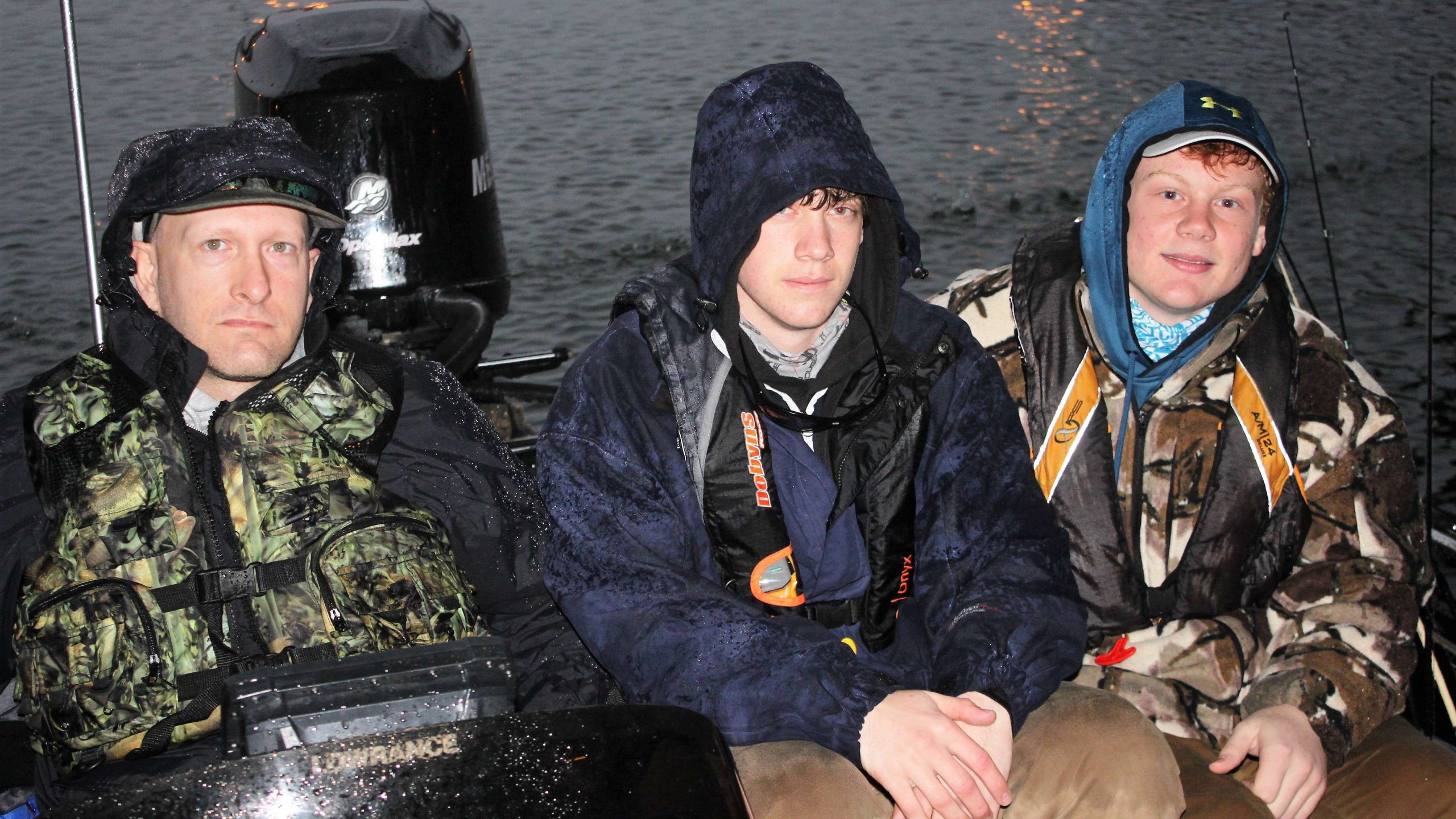 Captain Charles King, and anglers Draven Ray and Austin Shook of Plattsmouth Blue Devil Fishing in Nebraska wait out the rain under cover.