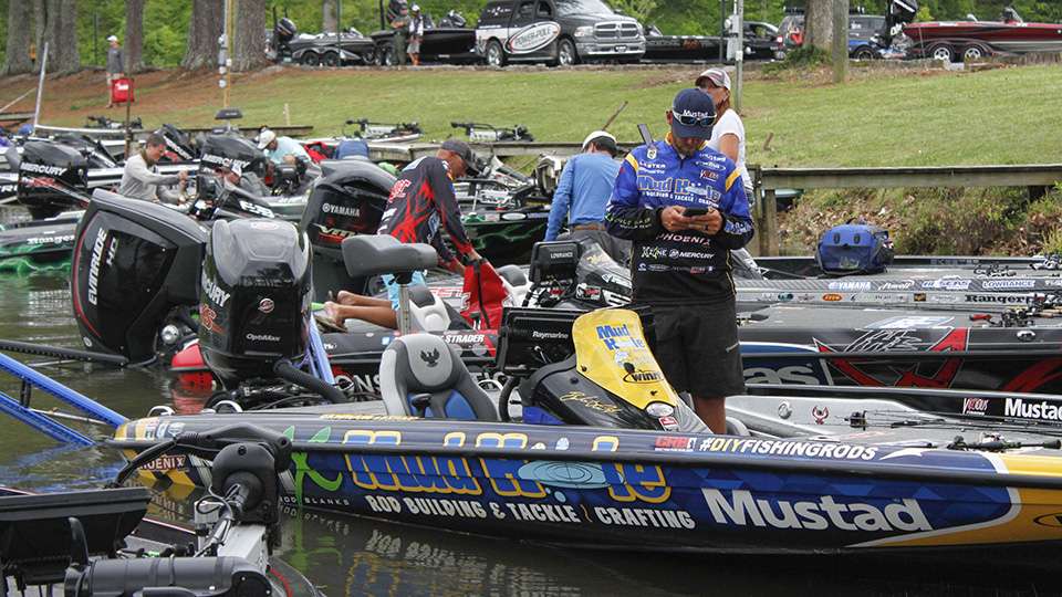 Brandon Lester checks the leaderboard to see if he has enough to fish the final day as Wesley Strader bags his fish next to him.