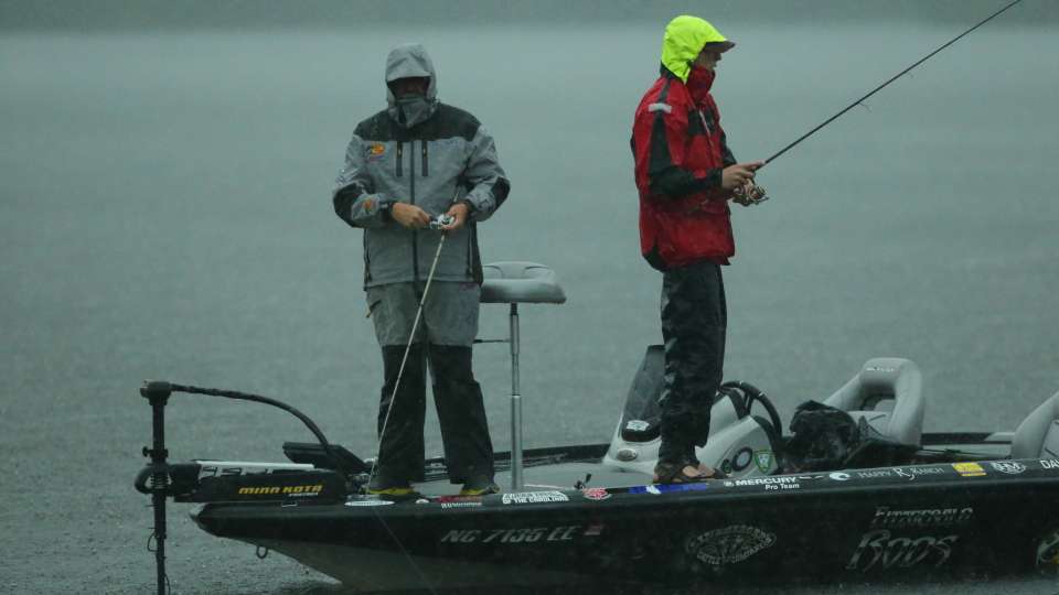 As it starts to rain, Marvin and Williams put on rain gear and keep fishing.