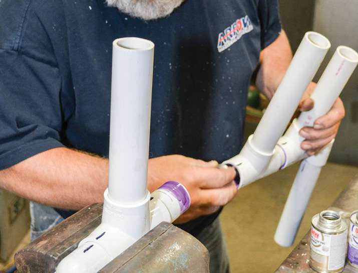 4. Two-part PVC cement locks it all together. Before gluing the rocket tubes, flare the ends with a heat gun and wine bottle. Scuff the PVC with a Scotch Brite scouring pad and spray it with paint that adheres to plastic.