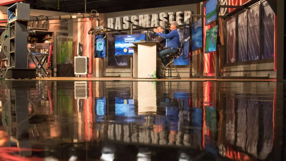 The two hosts of Bassmaster LIVE occupy the main desk. 