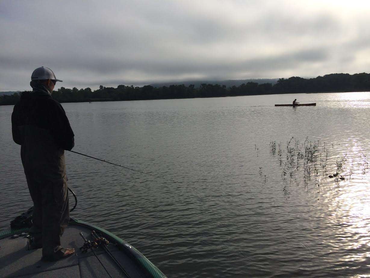 Marty Robinson keeps on fishing as this local kayaker goes by. A lot of boats sharing water already this morning.