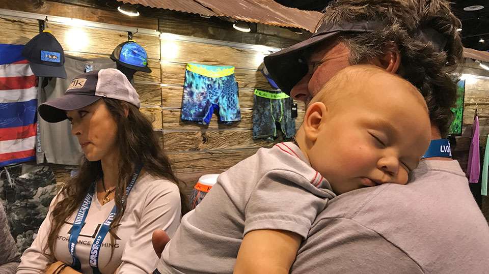 Bo Johnson of Tenacity Guide Service holds sleepy 7-month-old son, Gage, as wife, Deidra, talks fishing at the Huk booth. Sheâs been missing regular fishing outings and said she plans to get back out onto the water more very soon.