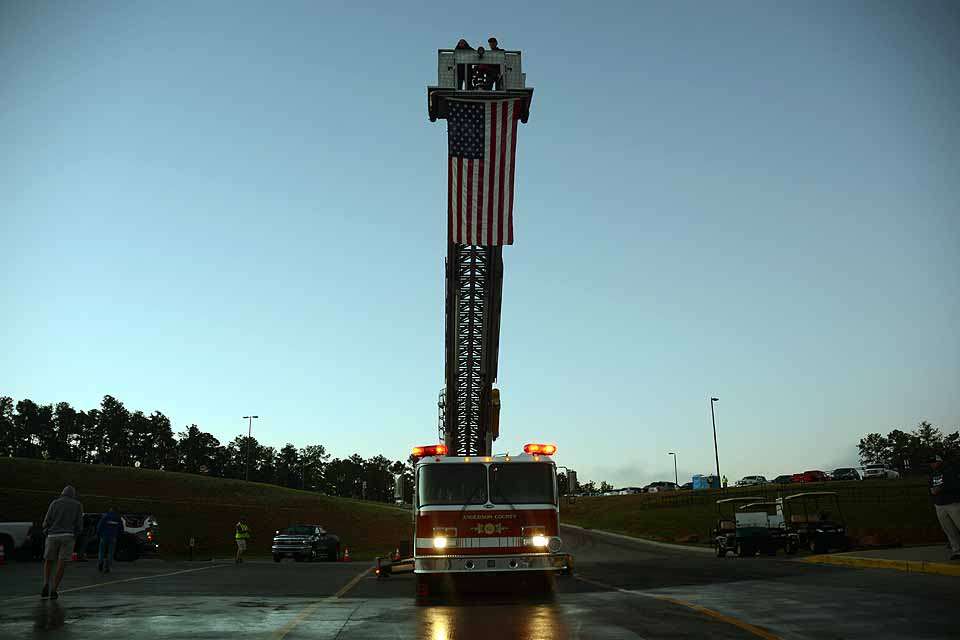The American flag is raised by the tower ladder truck. 
