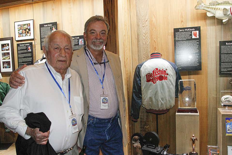 Steve Bowman and Bill Huntley stand by Jerry McKinnis' glass case which showcased a feature on his life and his iconic show 