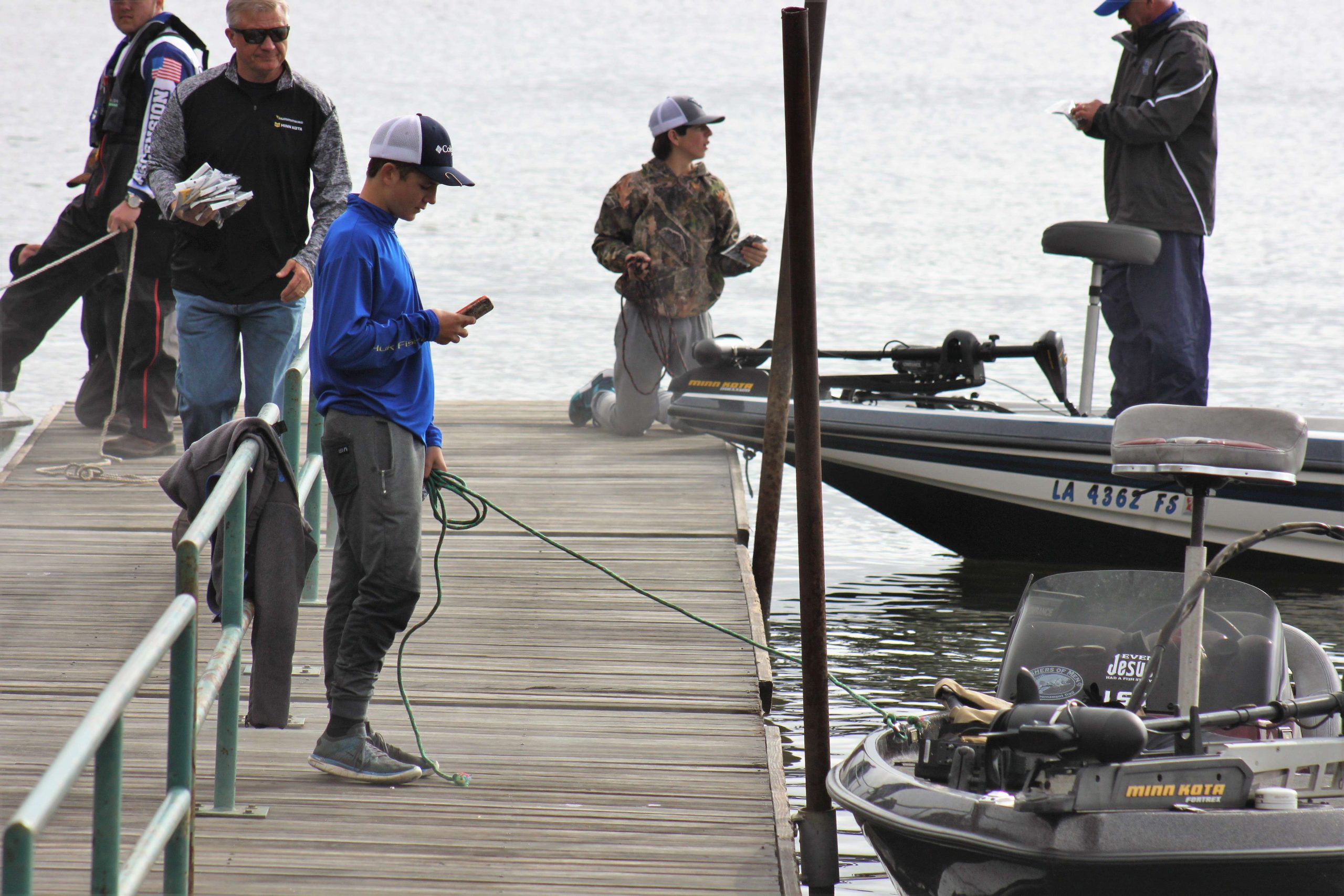 This angler scans his phone will keeping his ride close to the dock.