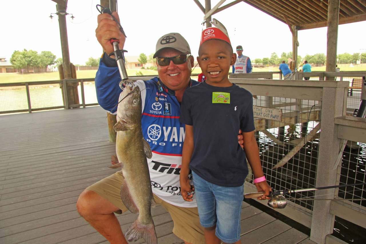 Scroggins holds a catfish nearly as long as 6-year-old Jordanâs leg. 
