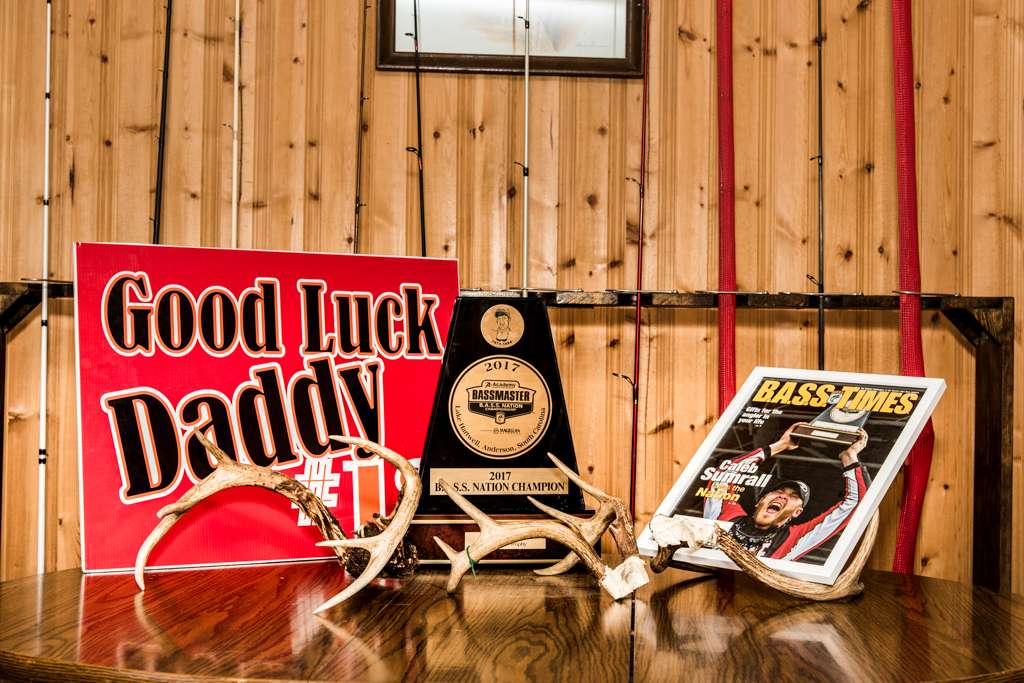 The focal point of Caleb Sumrallâs man cave is the table for his B.A.S.S. Nation Championship trophy. Also featured are the B.A.S.S. Times cover showing him celebrating that victory and a sign his daughter holds up when she attends tournaments. The deer antlers show that fishing isnât his only outdoor-related passion.