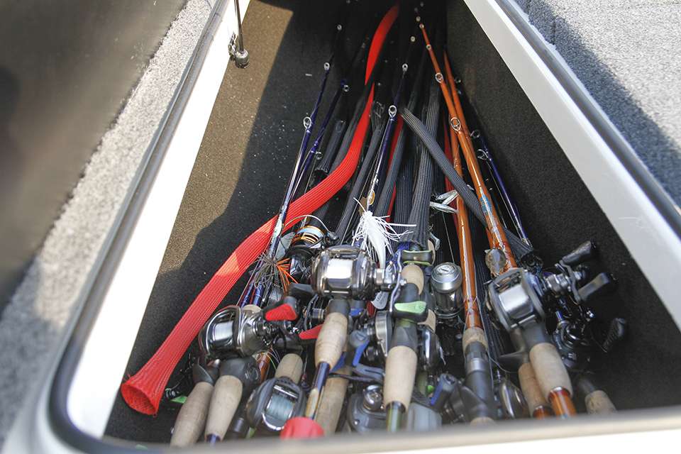 The left side of his boat is occupied by numerous rods.