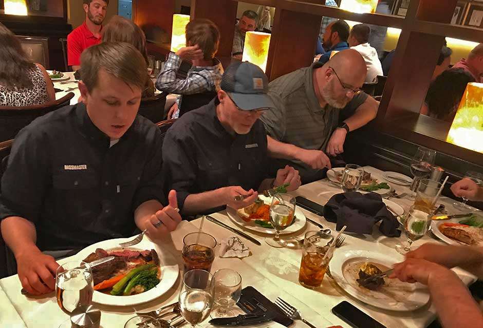 As a professional eater, I can appreciate fellow Bassmaster.com worker Chris Mitchell being nearly done with his meal while our digital chief, Jim Sexton, plays with his food, and Ronnie Moore, my partner in crime on Facebook Live during Elite events, had to wait for someone to cut his food. Jim will next teach him how to hold a fork.