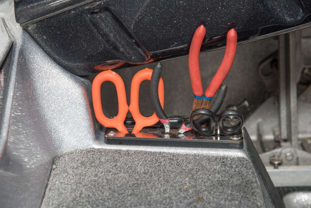  An assortment of pliers and scissors are kept handy in a slotted compartment near the console.