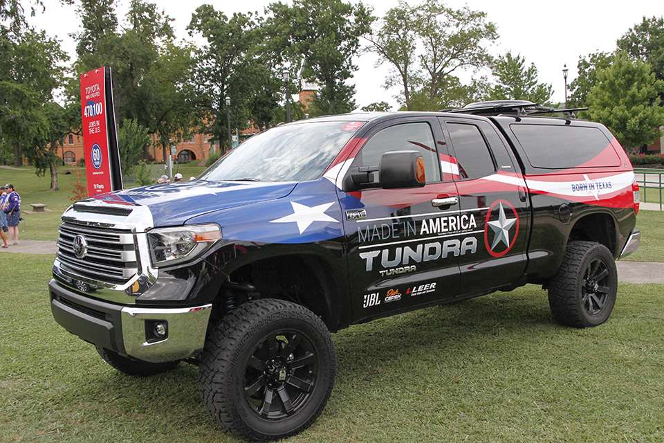 A decked out Toyota Tundra hangs nearby.