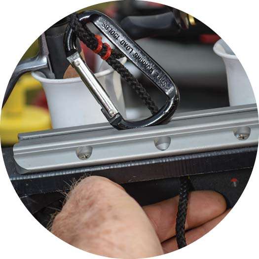 Attach an inexpensive carabiner to nylon cord with a pair of cable ties. Run the other end of the cord through a hole in the crate and tie an overhand knot.